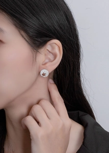 Close-up of S925 silver stud earring with micro-pave diamonds and star cutout on ear