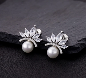 Macro shot of S925 sterling silver crown earrings with marquise zircons and white pearls