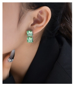 Close-up of elegant S925 silver drop earrings with emerald green ice-cut cubic zirconia