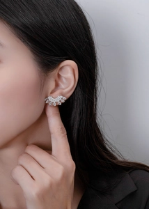 Close-up of fan-shaped silver stud earrings with marquise crystals on female model