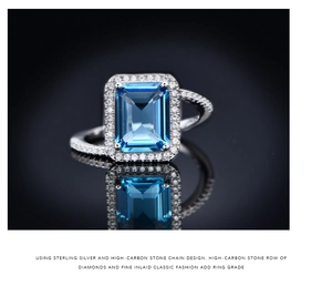 Macro shot of 925 silver ring featuring emerald cut blue stone and halo diamonds