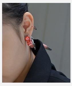 Close-up of elegant square red gemstone stud earrings featuring a classic four-prong setting