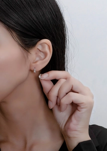 Close-up of small S925 sterling silver huggie hoop earrings with rectangular zircon