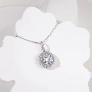 Détail d'un collier en argent 925 avec pendentif tournesol à double halo et pierre brillante