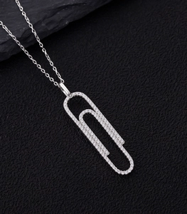 Macro shot of silver paperclip pendant set with brilliant pavé zircon stones on black leather