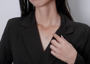 Close-up of S925 silver necklace with geometric ring and bar pendant on a model