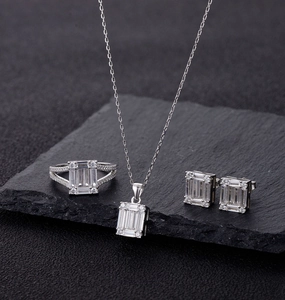 Macro shot of S925 silver jewelry set with emerald-cut zircon on dark textured stone