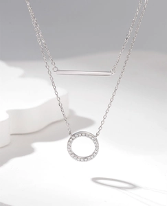 Detail of silver double-layer necklace with a polished bar and pavé zircon round pendant