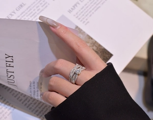 Close-up of stacked silver snowflake rings with round brilliant-cut zircon on model hand