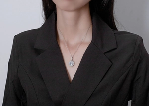 Gros plan d'un collier halo en argent 925 avec pendentif diamant ovale porté par un mannequin