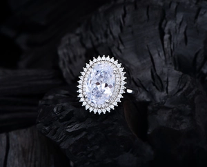 Détail macro d'une pierre de coupe ovale avec double halo sur bague en argent 925