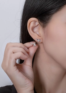 Close-up of S925 silver bow butterfly stud earrings with sparkling cubic zirconia on ear