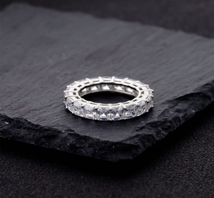 Vista macro di anello eternity in argento 925 con pietre taglio princess su base in pietra