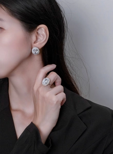 Close-up of S925 sterling silver oval halo stud earrings worn by a female model