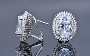 Detailed macro view of oval halo earrings with omega back and silver metal finish