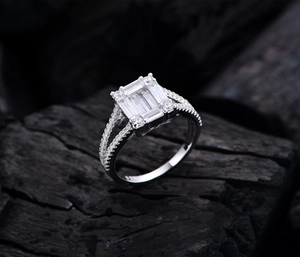 Macro shot of S925 sterling silver ring featuring emerald-cut cubic zirconia on black wood