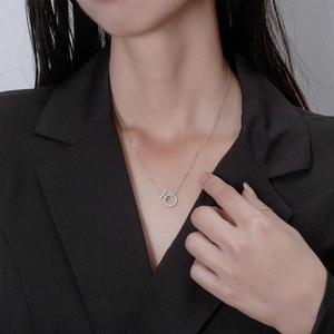 Elegant silver interlocking T-ring necklace with pave diamonds on female model