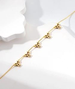 Detail view of 18k gold plated bracelet featuring elegant purple gemstone floral clusters