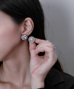Macro side view of 10mm round halo stud earrings in S925 silver on a model