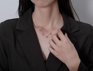 Detail of 18k gold plated necklace featuring five elegant purple gemstone clusters