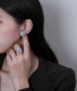 Detail of 10mm round cut moissanite ring and earrings set in sterling silver
