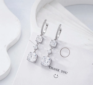 Détail macro du poinçon S925 en argent massif et boucles d'oreilles taille Asscher