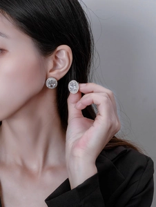 Close-up of luxury oval halo stud earrings with sparkling cubic zirconia on model