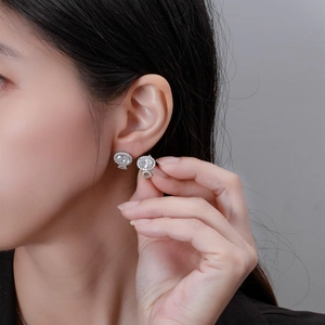 Boucles d'oreilles en argent 925 avec zircone ovale et halo portées par un mannequin