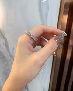 Vista laterale macro dell'anello d'argento con zirconi a taglio smeraldo a fascia intera
