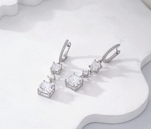 Détail de boucles d'oreilles en argent S925 avec trois cristaux de taille Asscher
