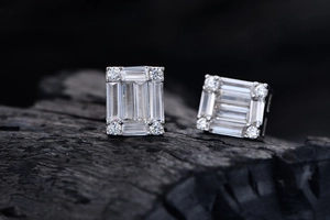 Macro detail of S925 silver baguette-cut earrings on textured black background