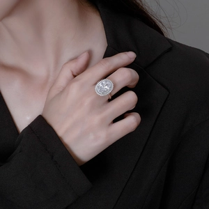 Bague de fiançailles halo ovale en argent S925 portée par un mannequin en blazer noir
