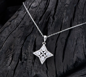 Macro detail of S925 silver star pendant with pear-shaped stones and pavé diamonds