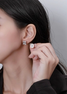 Macro shot of S925 sterling silver rectangular step-cut earrings with pavé halo