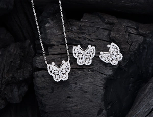 Détail du parure de bijoux papillon avec collier et boucles d'oreilles scintillants