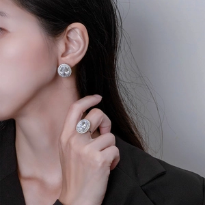 Oval silver stud earrings and ring set with halo crystals on elegant female model