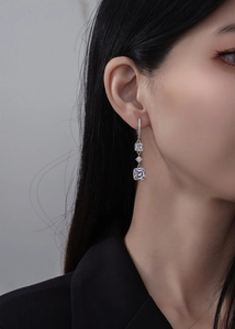 Détail de boucles d'oreilles pendantes en argent sterling 925 avec diamants taille émeraude