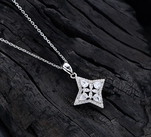 Detailed macro view of S925 silver star pendant with cubic zirconia on black wood