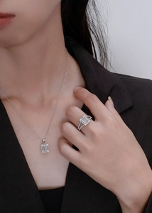 Detail of S925 silver necklace and ring set with emerald cut cubic zirconia on a model