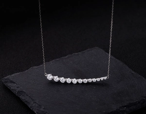 Detailed macro view of a curved silver sterling necklace with shining zircon stones
