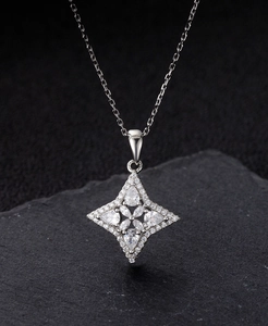 Macro shot of silver four-pointed star pendant with micro-pave cubic zirconia crystals