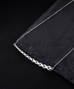Macro shot of S925 sterling silver bar necklace with sparkling cubic zirconia on a dark stone