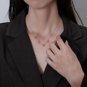 Elegant 18k gold plated necklace with purple floral gems worn by model on black suit