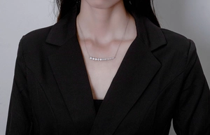 Sparkling silver necklace featuring curved sparkling stones worn with a black blazer