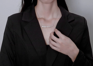 Detail of a sparkling silver necklace featuring graduated round crystals on a delicate chain