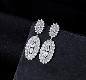 Macro de boucles d'oreilles argentées en forme de goutte avec zircons sur pierre noire