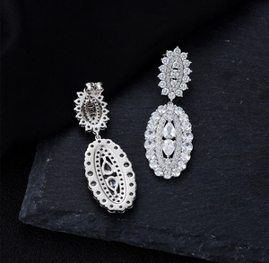 Détail de boucles d'oreilles de luxe en argent S925 avec pierres ovales sur roche