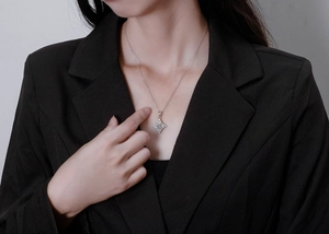 Close-up of a sparkling silver star pendant necklace worn with a black blazer