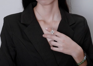 Detail of silver North Star pendant necklace with micro-pave diamonds on black suit