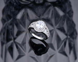 Detailed close-up of 925 sterling silver stamp and sparkling oval cut halo ring